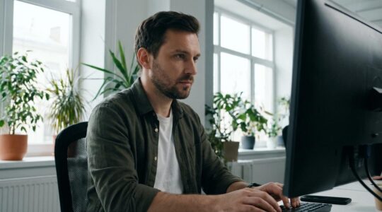 Développeur web créant un site sur mesure dans un espace de coworking lumineux