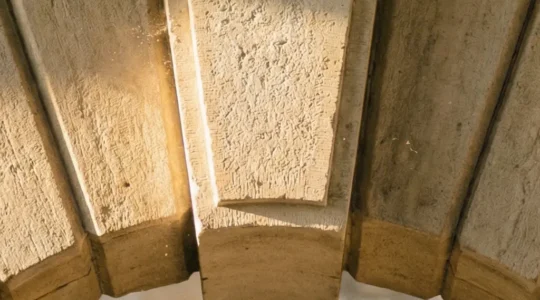 Vue architecturale d'une clé de voûte en pierre au centre d'une arche, symbolisant le rôle fondamental du contenu pilier dans une stratégie SEO